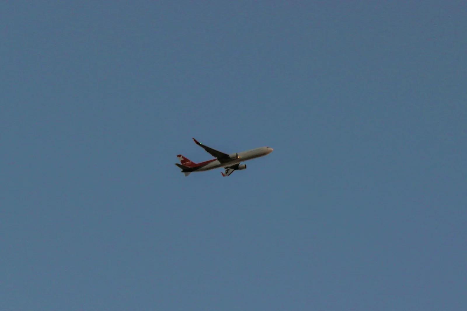 An aircraft on climb-out against the dusk sky over Dubai International.